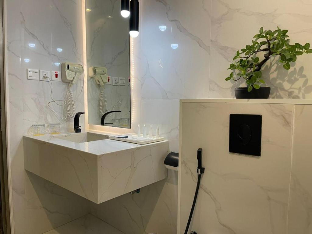 a white bathroom with a sink and a mirror at شير فل الرس in Ar Rass