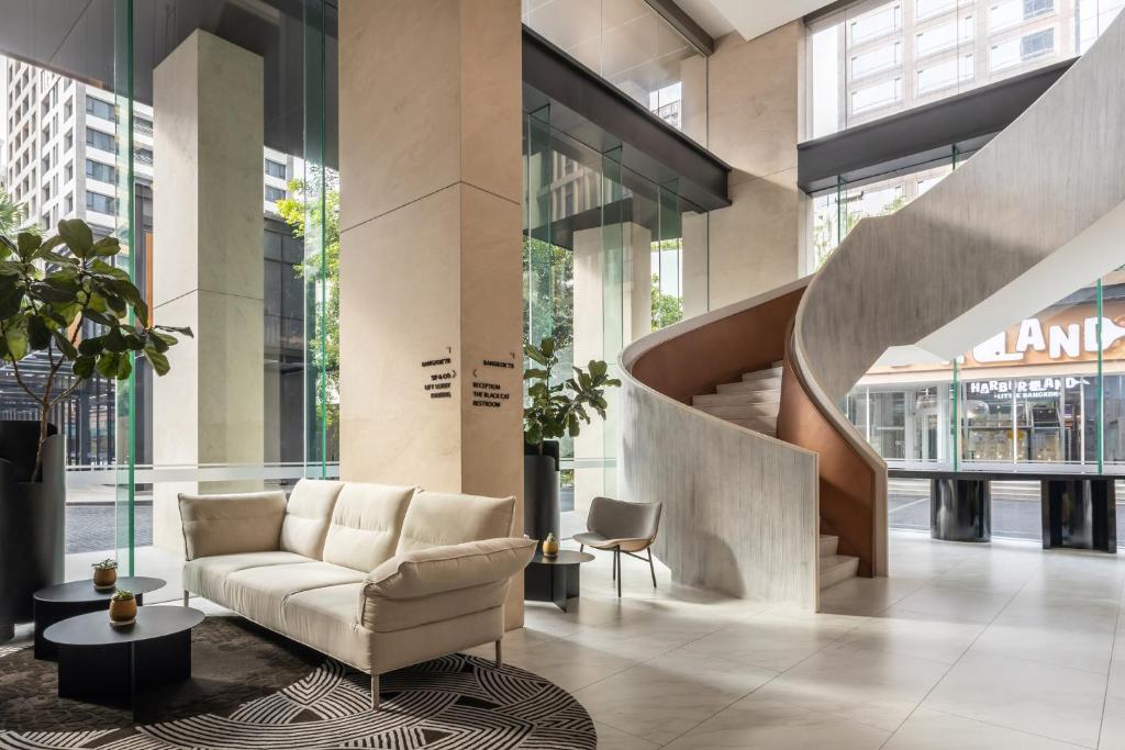 A bright lobby combines a cream sofa with a sculptural curved staircase.