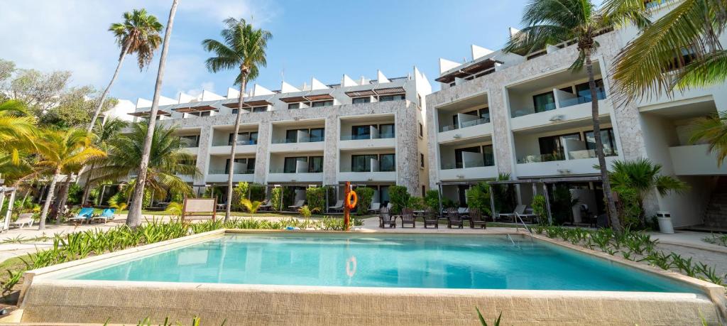 a hotel with a swimming pool in front of a building at Akumal Bay Beach & Spa Resort in Akumal