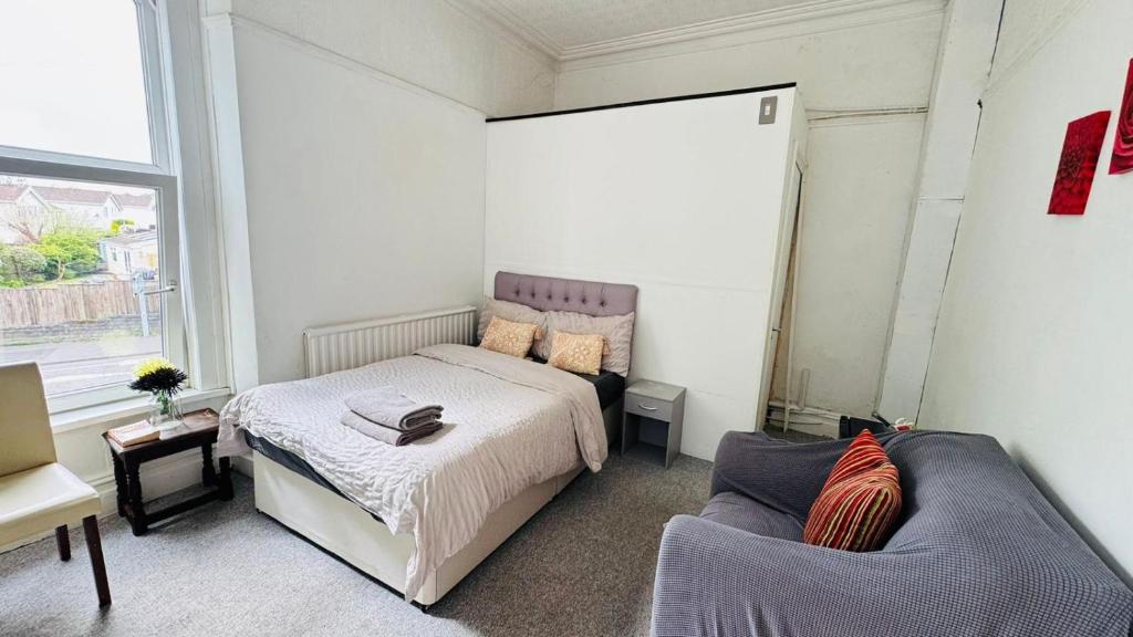 a bedroom with a bed and a couch at Singleton Double Studio Room with Private En-Suite in Sketty