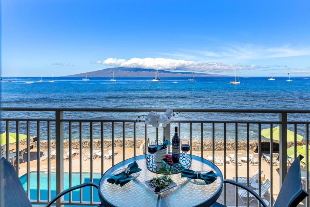 a table on a balcony with a view of the ocean at OB - Lahaina Roads 308 in Lahaina