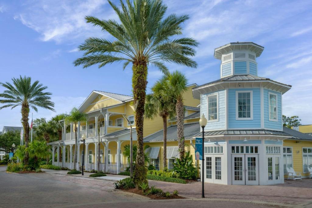 a yellow house with palm trees in front of it at Marriott's Harbour Lake in Orlando