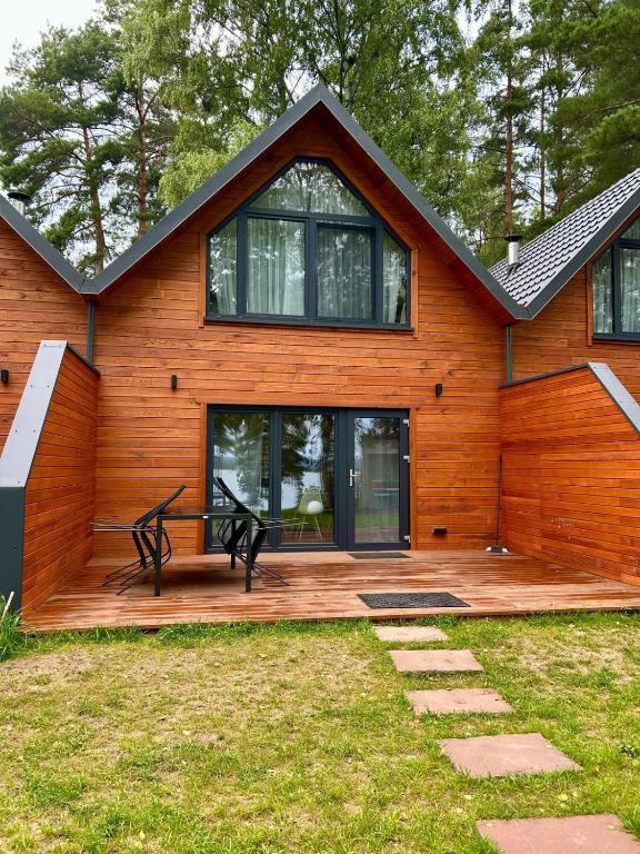 a house with a wooden deck in front of it at Dadajówka Domki przy plaży in Wilimy