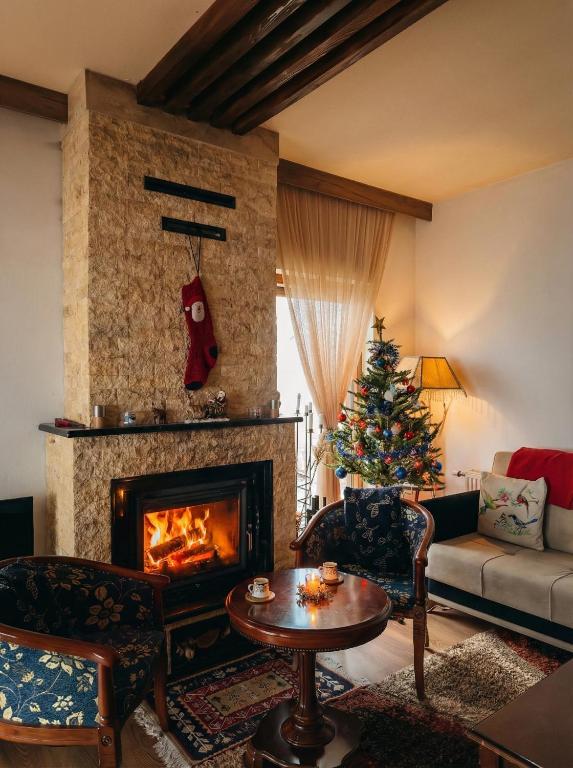 a living room with a christmas tree and a fireplace at Villa Harmonia in Ferizaj