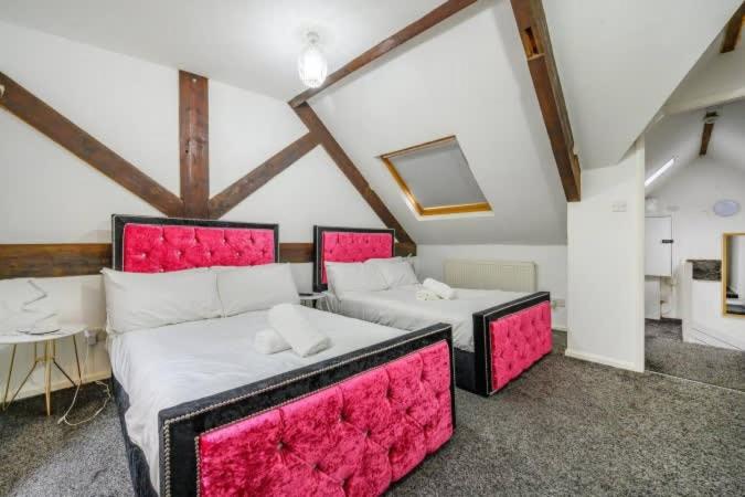 a large room with two beds with pink frames at RB1GH- Cosy Room SECURE PARKING NEAR CITY CENTRE FAST WIFI in Bramley