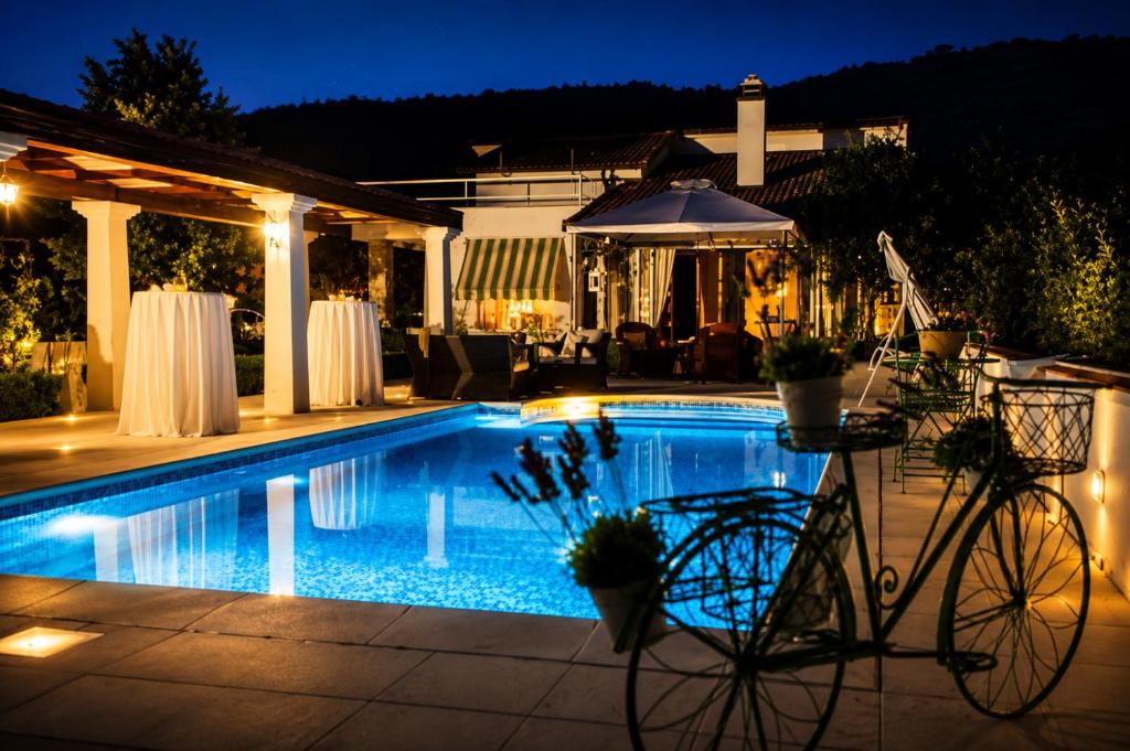 a swimming pool at night with a bike next to it at Villa Maslina in Ljubuški