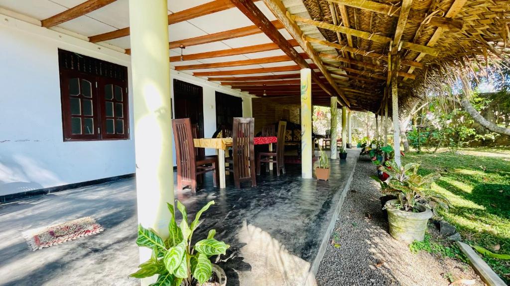 a porch of a house with chairs and plants at D n A secret Palace in Tangalle