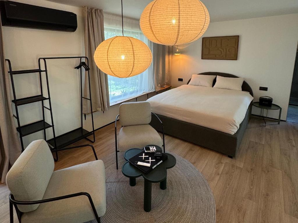 a bedroom with a bed and two chairs and a table at Garden 52 in Šutovce