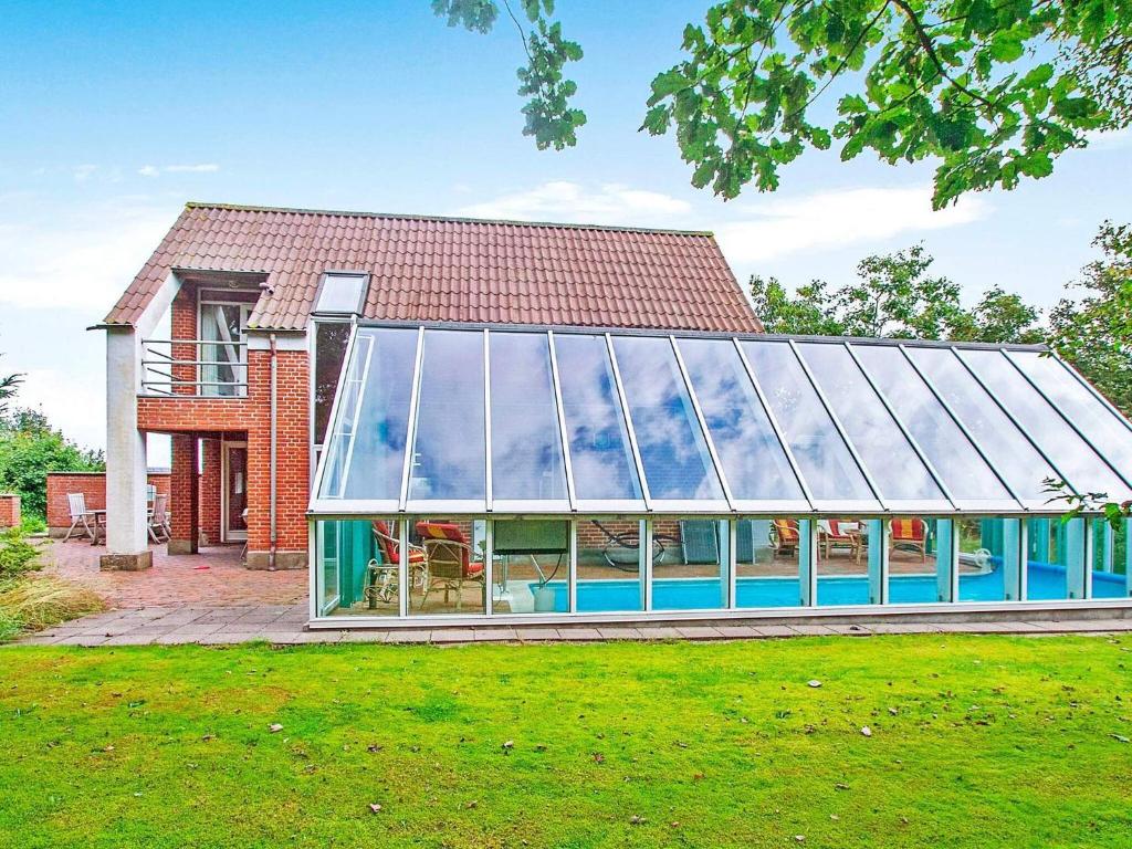 a large glass house with a pool in the yard at 6 person holiday home in Farsø in Hvalpsund
