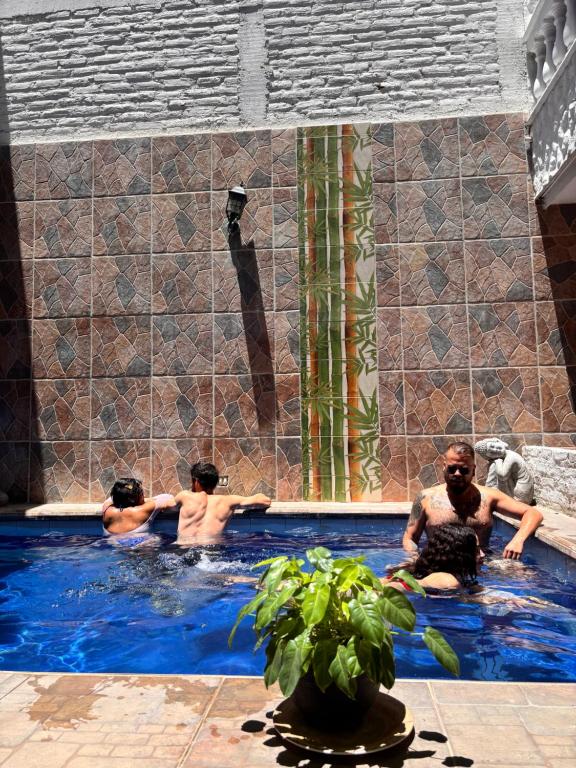 a group of people in a swimming pool at Hostal Casa Lulú Santa Marta in Santa Marta