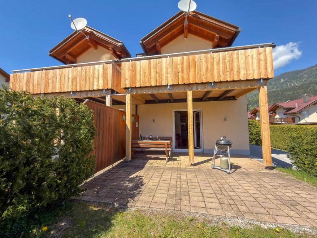 a house with a deck on top of a patio at Kipaji 3 in Kötschach