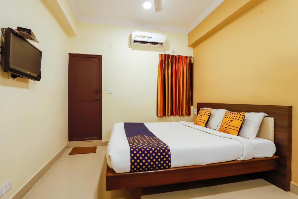 a bedroom with a bed and a flat screen tv at SPOT ON Central Inn in Chennai