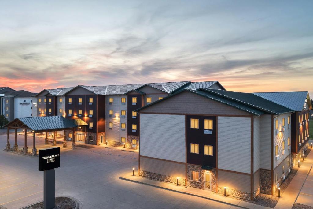 a rendering of a row of apartment buildings at dusk at TownePlace Suites by Marriott Minot in Minot