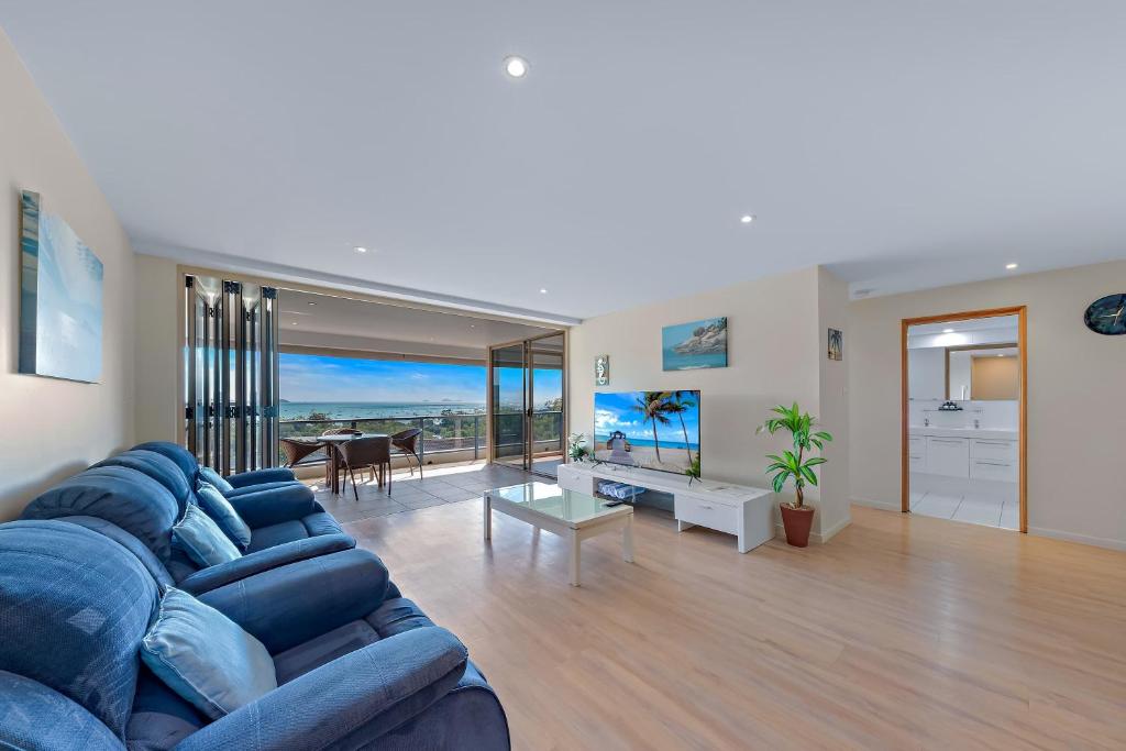 a living room with a blue couch and a table at Getaway Ocean Views KIDS STAY FREE in Airlie Beach