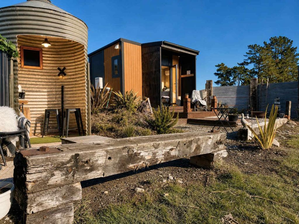a home with a silo and a wooden fence at Field and Fleece Farm Stay by Tiny Away in Claremont