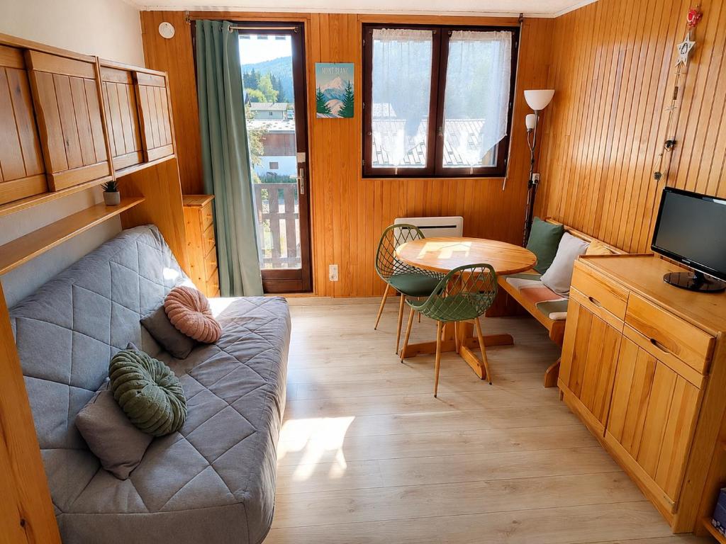 a living room with a couch and a table at L'HappyMijoux in Mijoux