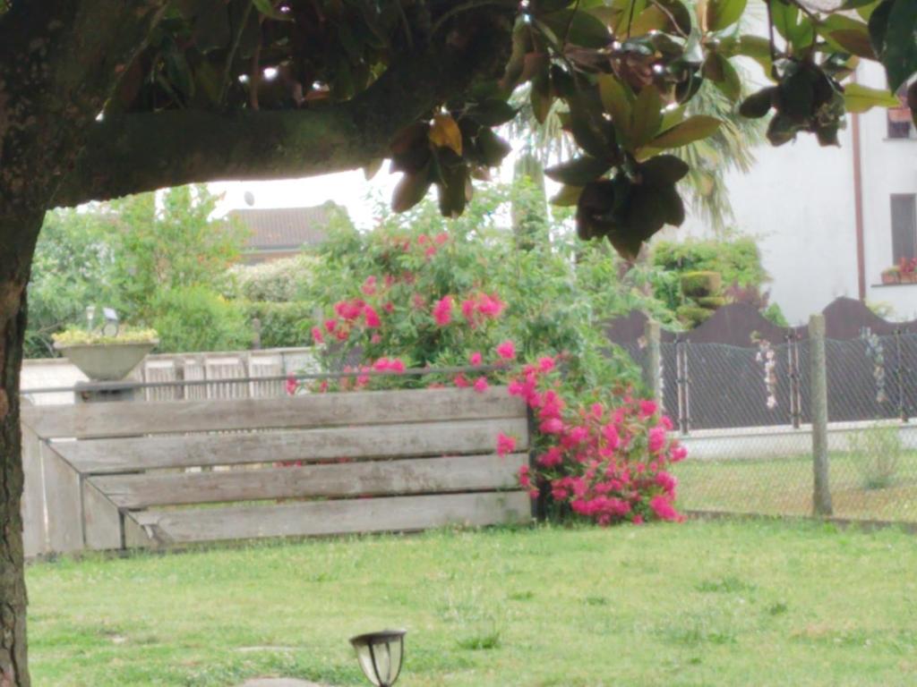 a bench with pink flowers in a park at Room Bed Garden in Berra