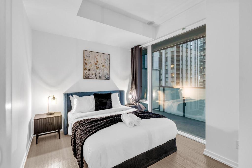 a bedroom with a large bed and a large window at The C Park Hotel and Suites in Toronto