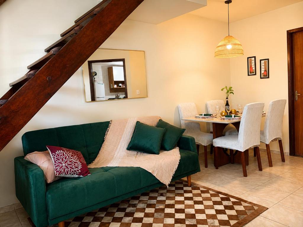 a living room with a green couch and a table at Casa à Beira Mar em Praia Seca Araruama RJ in Araruama