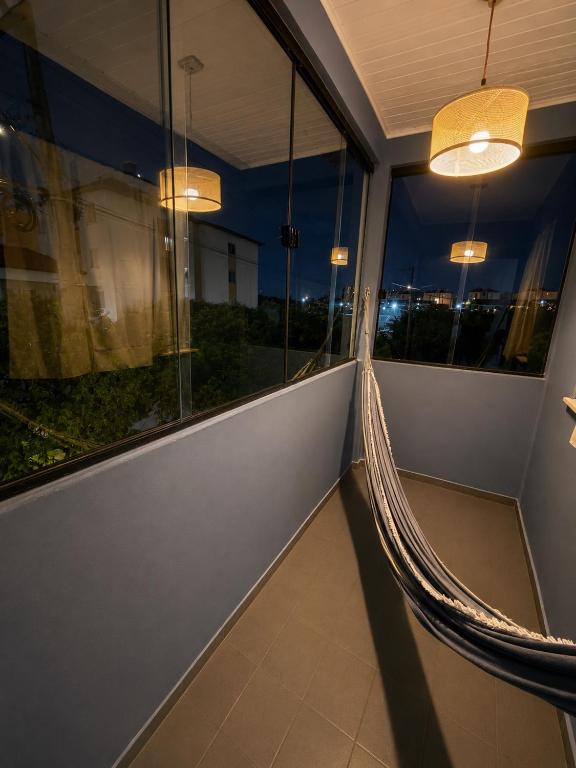 a balcony with a hammock in a room with windows at Apartamento em localização estratégica em Aracaju in Aracaju