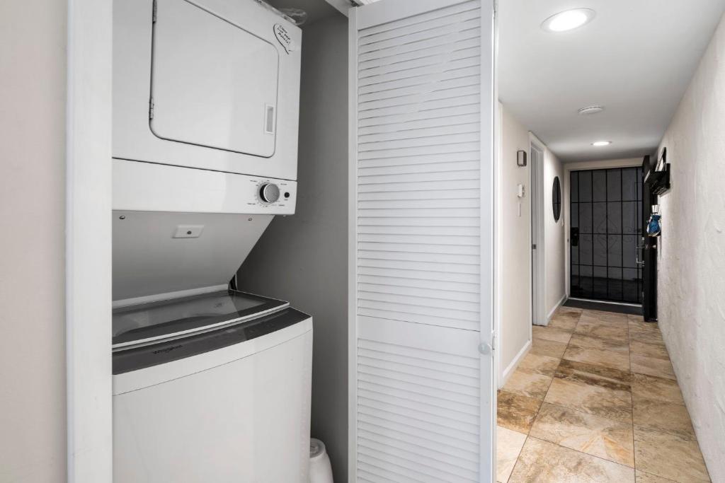 a kitchen with a washer and dryer and a hallway at Casa De Emdeko 104 in Kailua-Kona