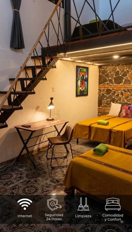a room with two beds and a desk and a staircase at Casa Alejandro de los caballeros in Antigua Guatemala