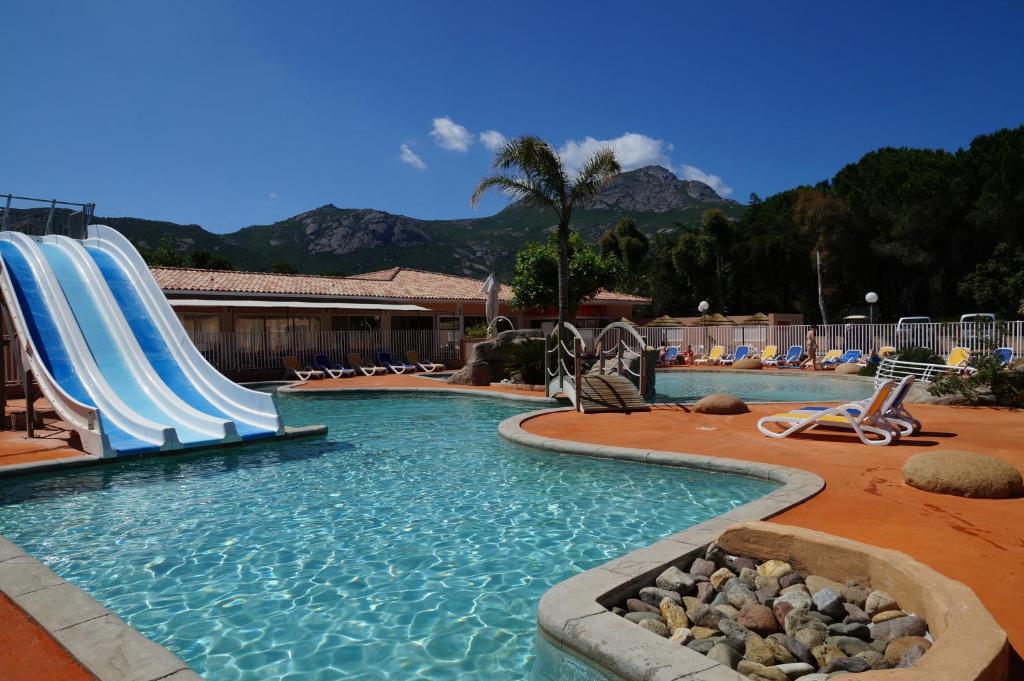 a pool with a water slide in a resort at Camping Les Castors in Calvi