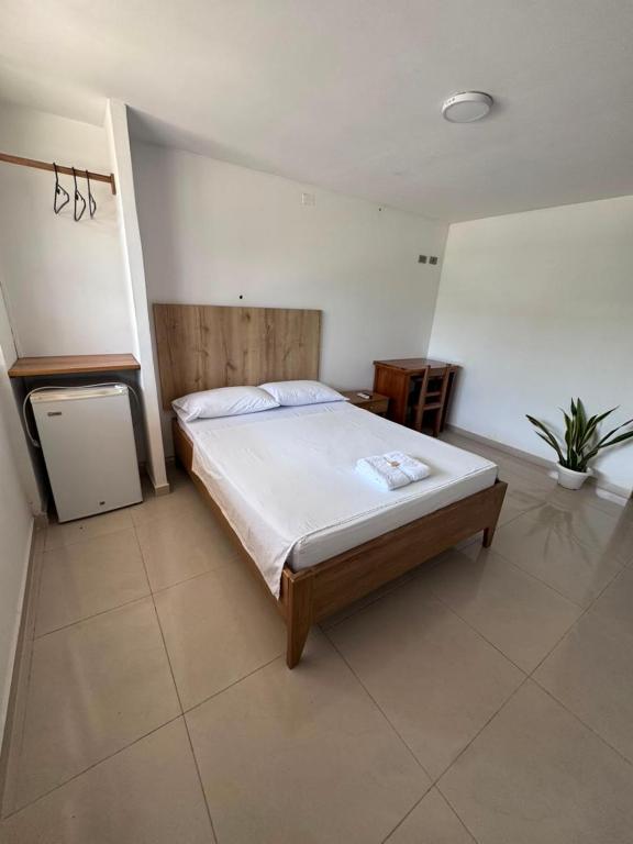 a bedroom with a large bed in a room at ApartaHotel Los Naranjos in Apartadó