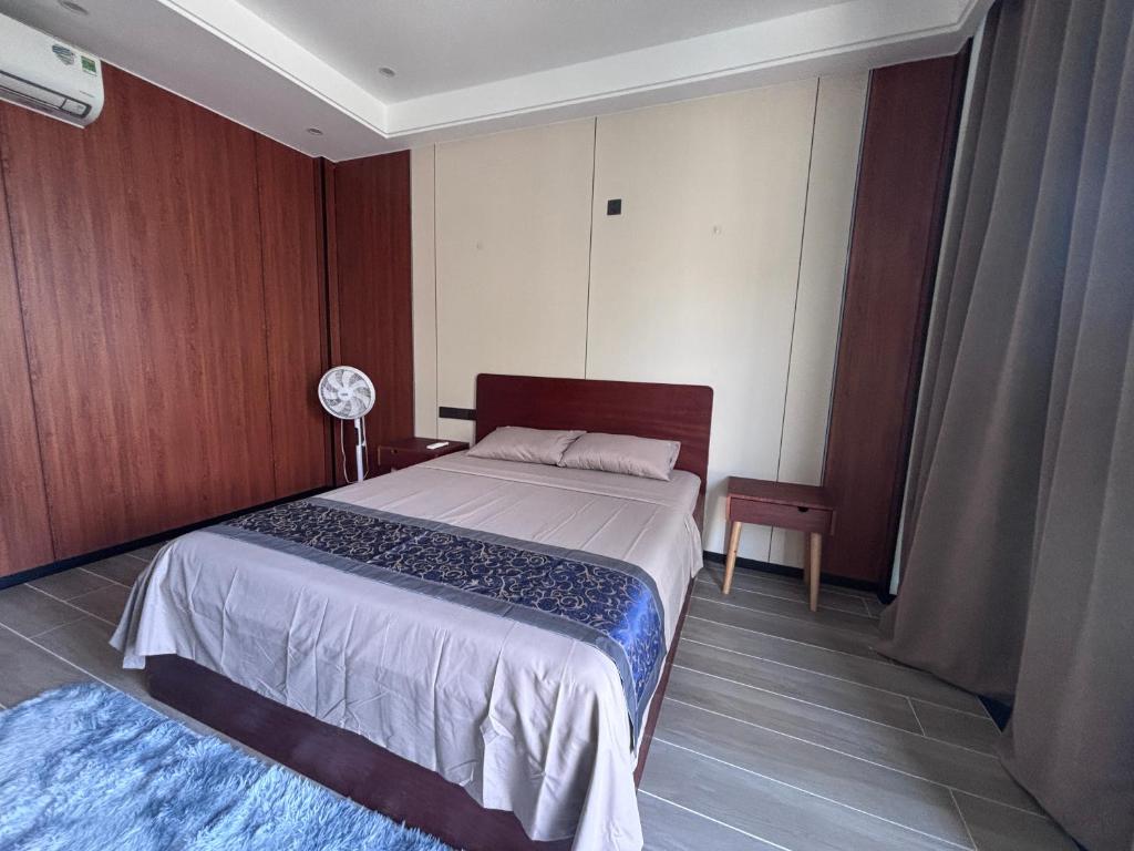 a bedroom with a bed and a table and a fan at D02 - Happy Beach Villas - No2 Căn hộ Z&Z Triple key - NovaWorld Ho tram in Binh Chau