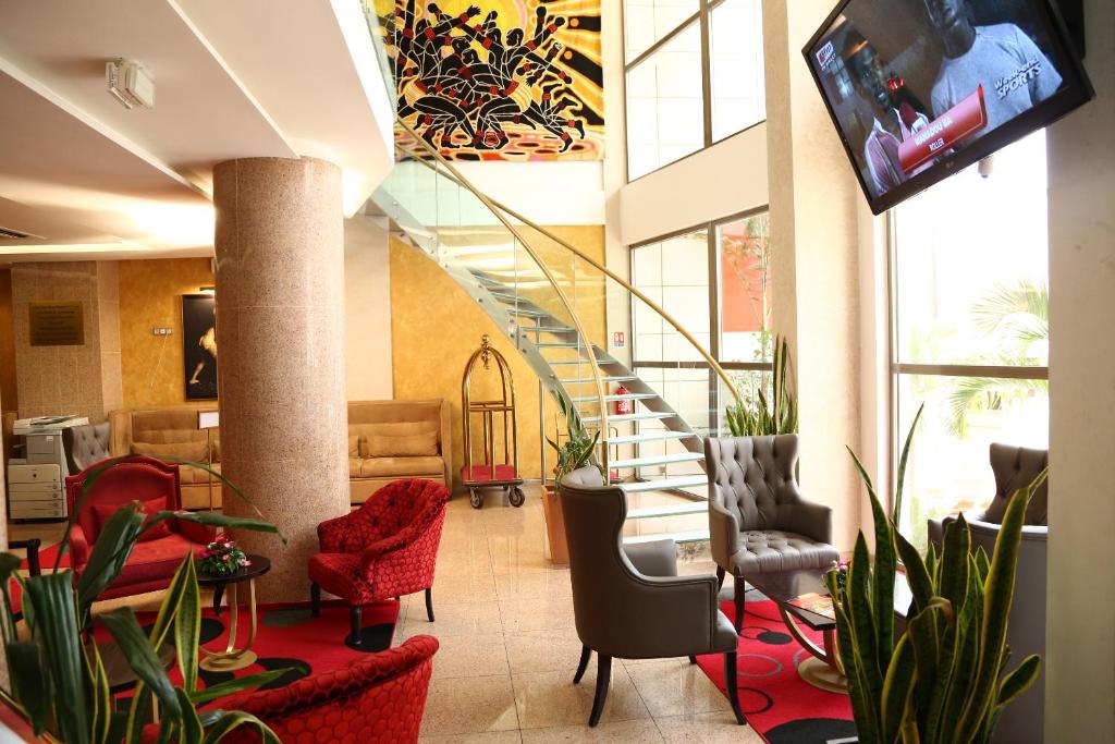 a lobby with chairs and a staircase in a building at Hôtel Fleur de Lys Plateau in Dakar