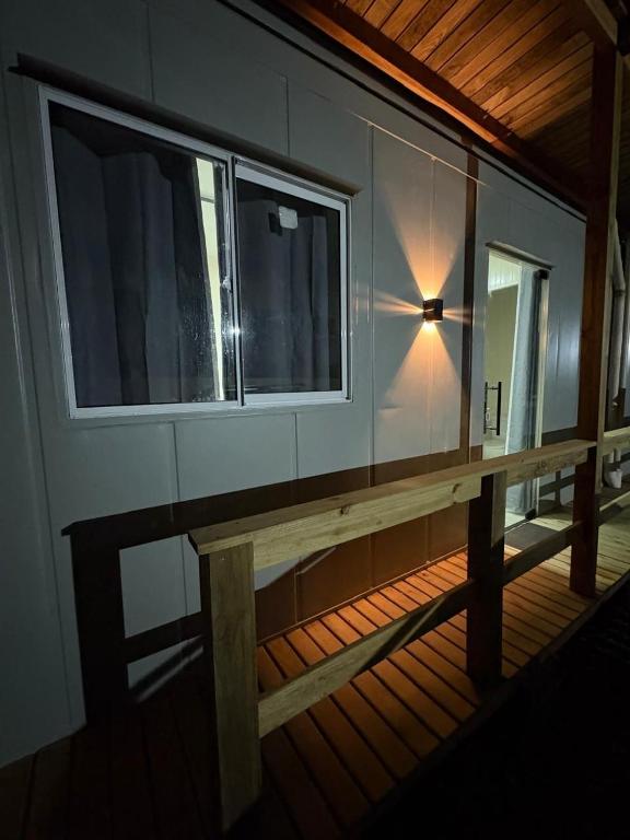 a wooden bench on a house with a window at Contêineres em Bombinhas in Bombinhas