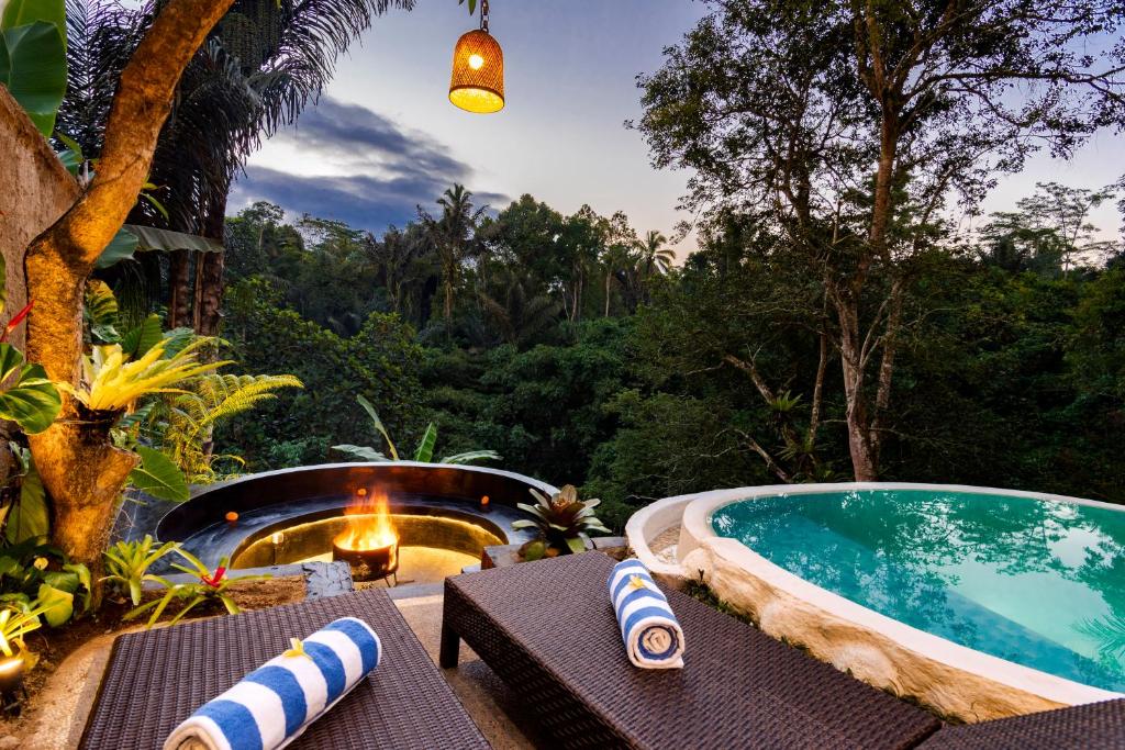 an outdoor swimming pool with chairs and a table at Uma Harum Sari by Dhananjaya Hospitality in Penginyahan