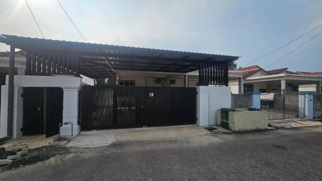 a house with a black gate and a fence at Homestay Sulong in Kuala Rompin