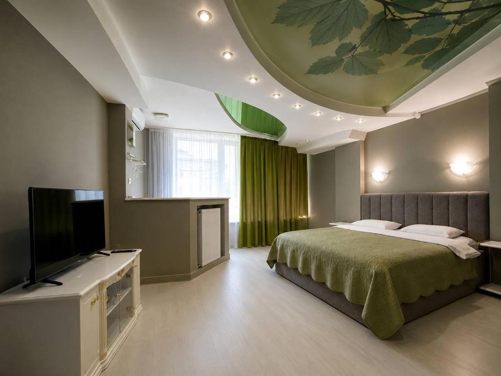 a bedroom with a bed and a flat screen tv at Апартаменти Мост Сіті in Dnipro