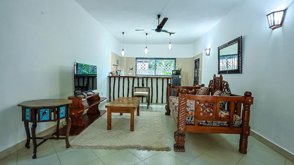 a living room with wooden furniture and a table at Janari Stays in Kilifi