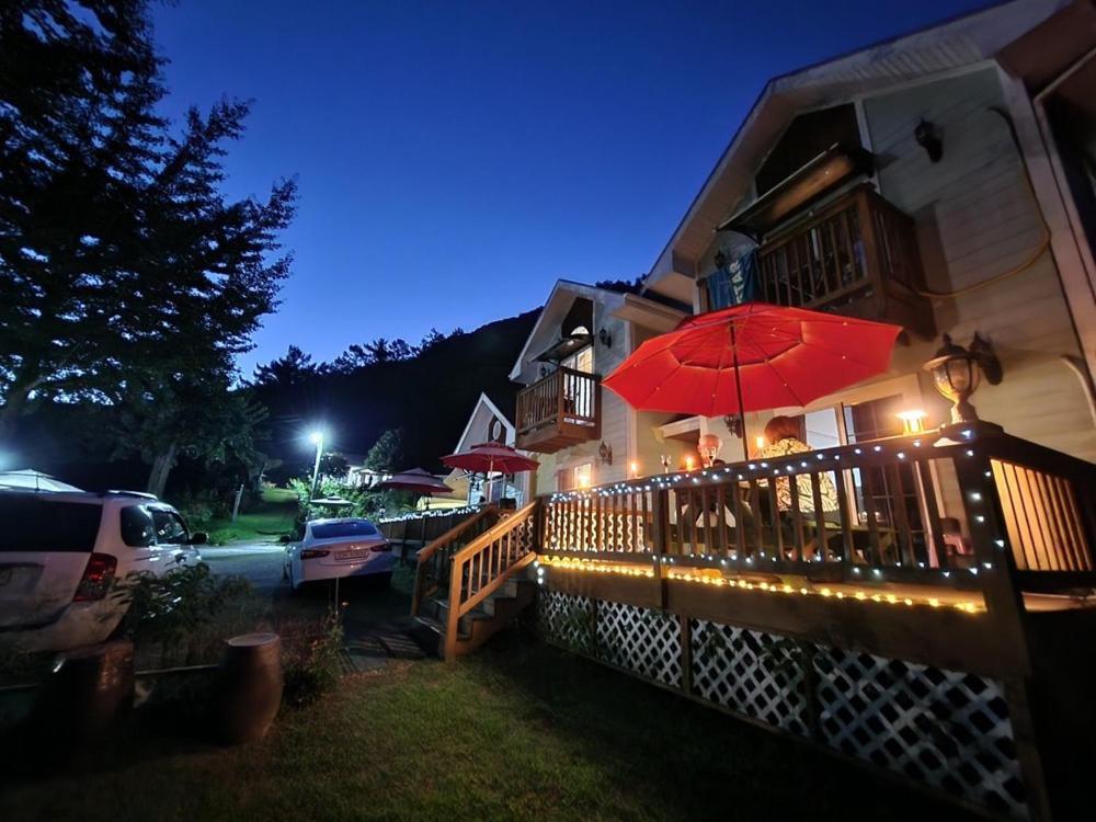 a restaurant with a red umbrella on a fence at Hwacheon Sankkun-uijib Pension in Hwach'ŏn
