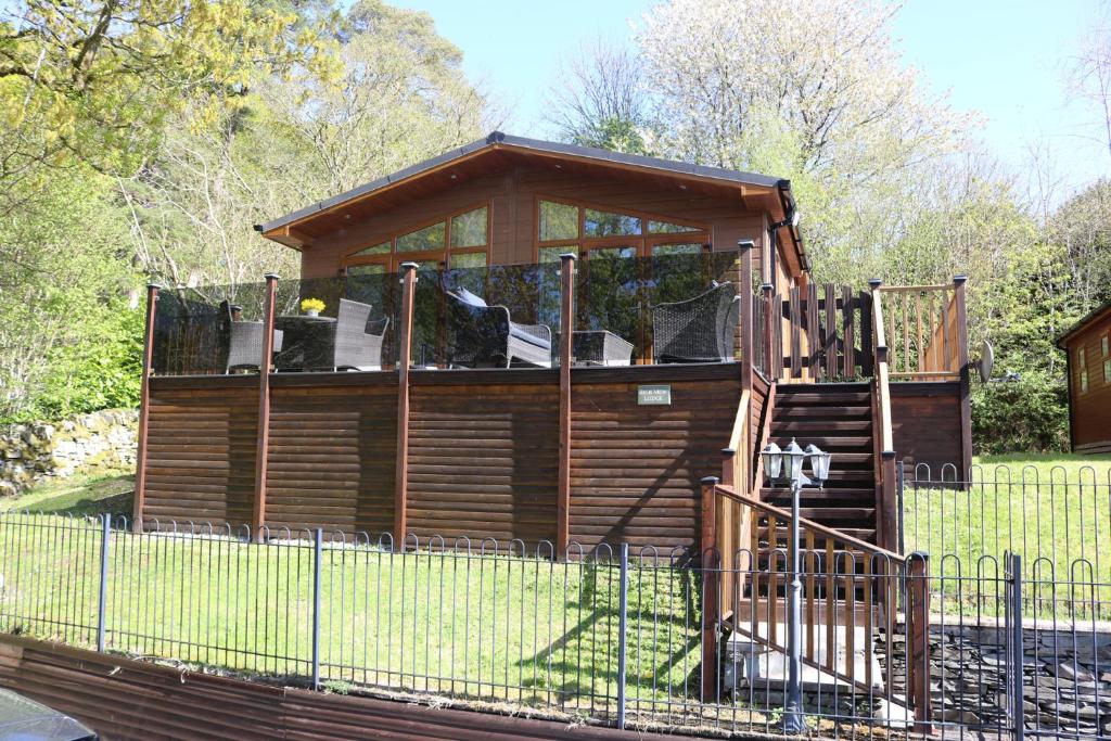 a wooden gazebo in a yard with a fence at High View Lodge in Windermere