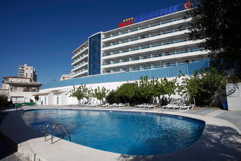 Hotel Natura Park في كوماروغا: فندق فيه مسبح امام مبنى