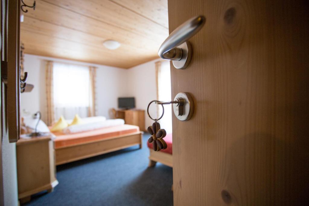 a bedroom with a bed and a door with a door knob at Thomashof in Pfelders