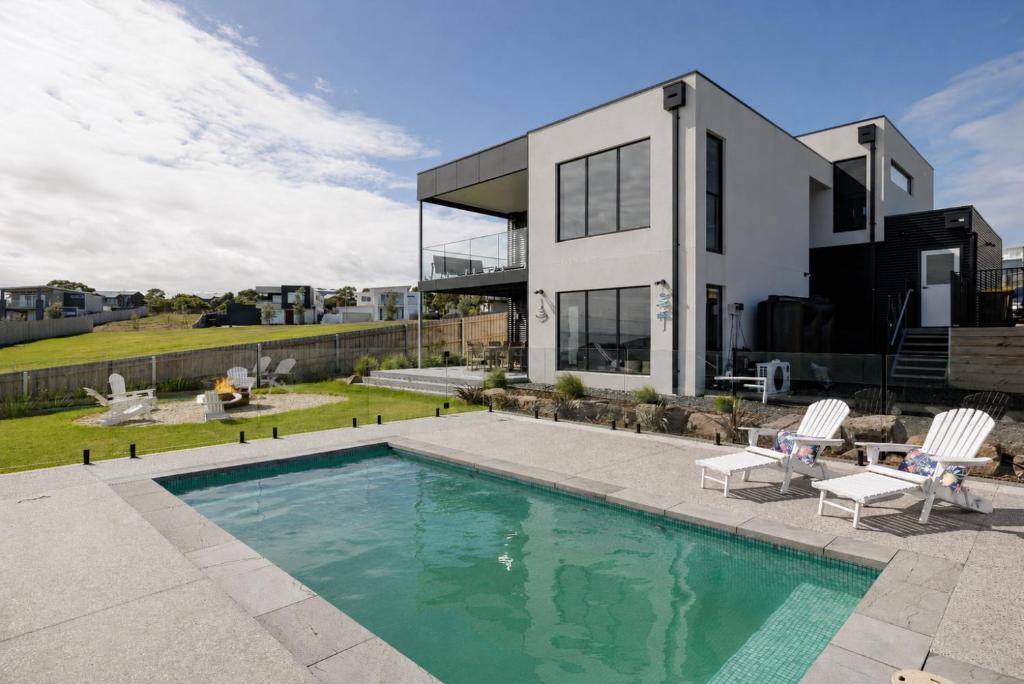 a house with a swimming pool in front of it at The Bay View San Remo by Ready Set Stay- BYO LINEN & TOWELS in San Remo