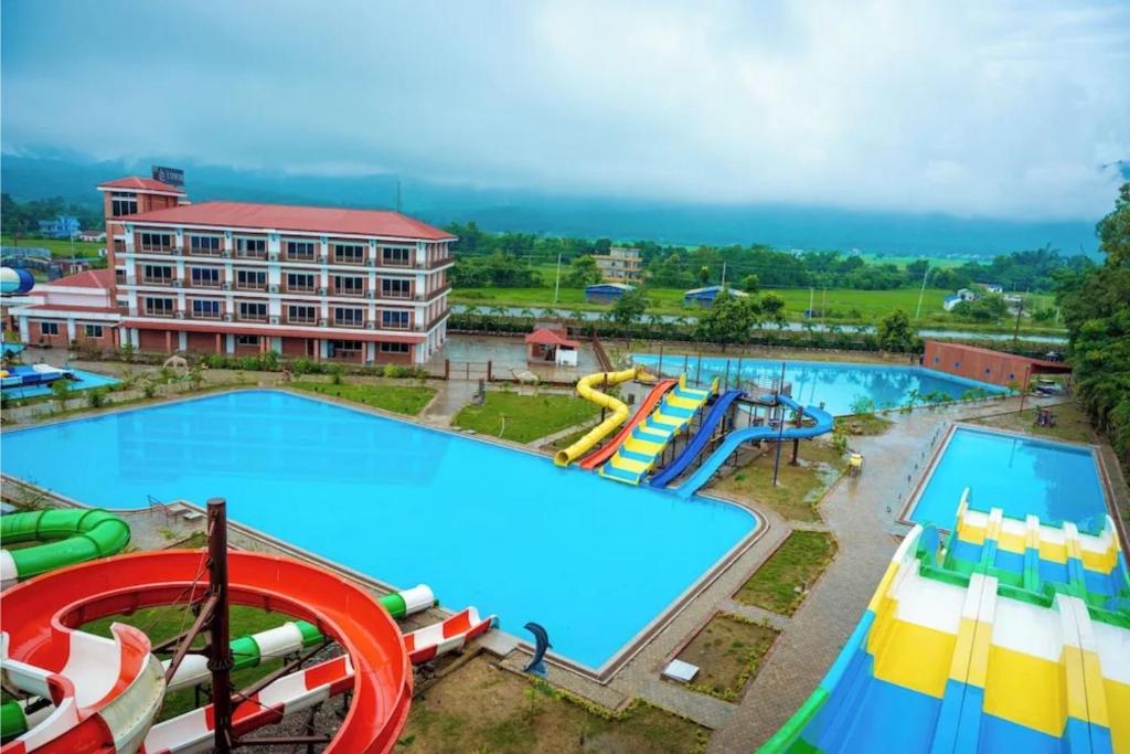 a large swimming pool with a water park at ila Comfort Harkapur in Maruwā Ghāt