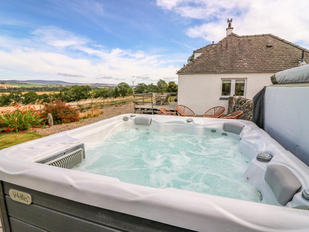 a hot tub on the back of a house at Whitehouse Woodwrae in Forfar