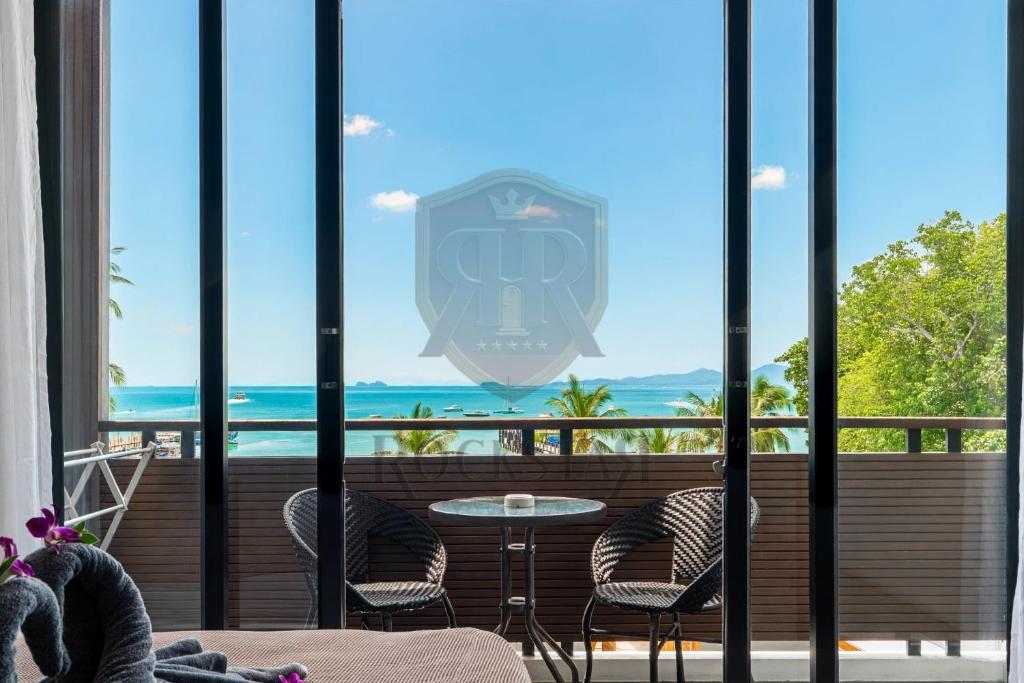 a view of the ocean from the balcony of a hotel at Rockstar Beach Apartments in Bangrak Beach