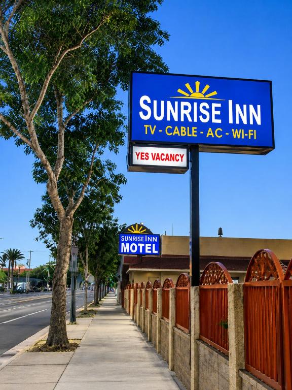 a sign for a sun rise inn on a sidewalk at Sunrise Inn in South Gate