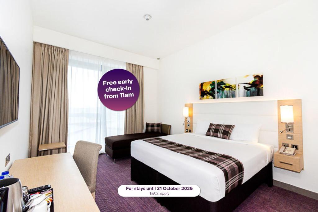 a hotel room with a bed and a desk at Premier Inn Dubai Dragon Mart in Dubai