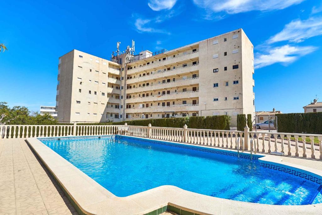 a building with a swimming pool in front of a building at Espanhouse Vera Torreblanca in Torrevieja