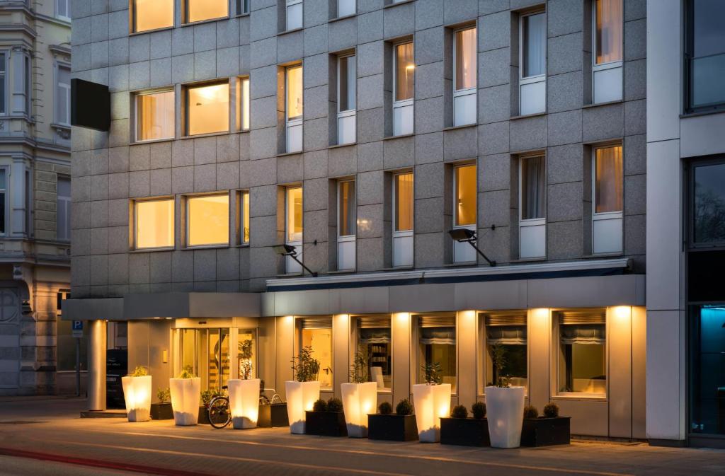 a building with white chairs in front of it at elaya hotel hannover city, Trademark by Wyndham in Hannover