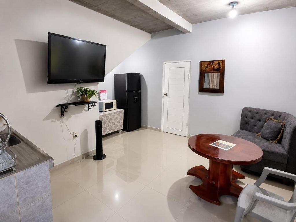 a living room with a table and a tv on the wall at Vista colonial suite in Comayagua