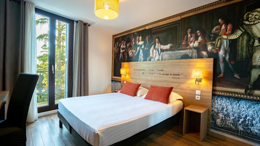 a bedroom with a bed with a painting on the wall at The Originals Boutique, Le Grand Hôtel Molière, Pézenas in Pézenas