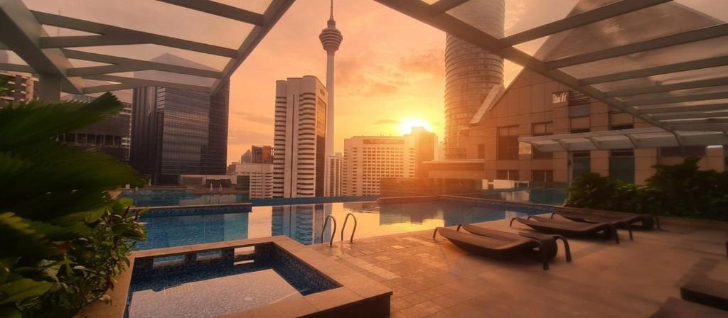 a swimming pool in a building with a view of a city at Cormar Suites Kuala Lumpur in Kuala Lumpur
